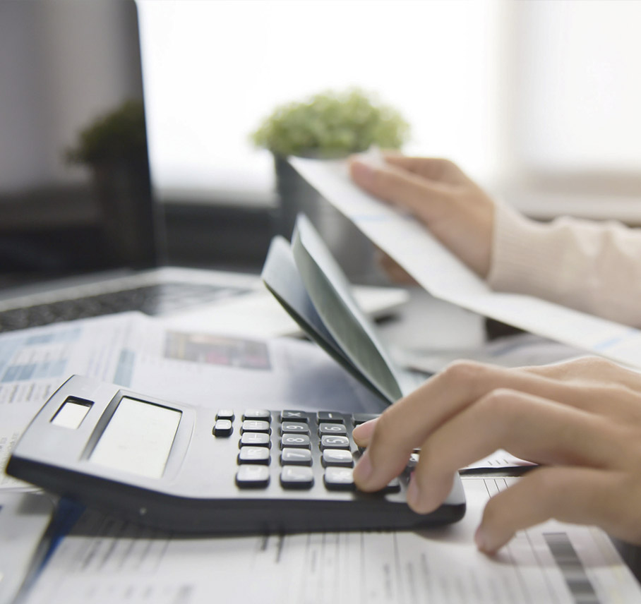 Persona trabajando con documentos financieros y calculadora